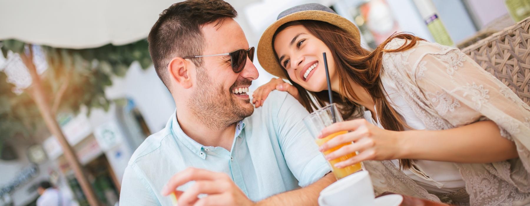 a man and woman sitting at a table and smiling