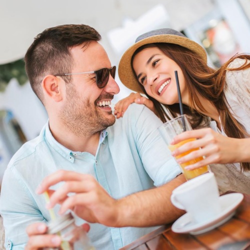 a man and woman sitting at a table and smiling