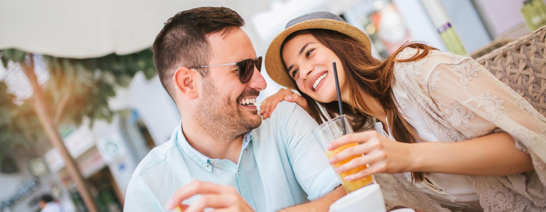 a man and woman sitting at a table and smiling